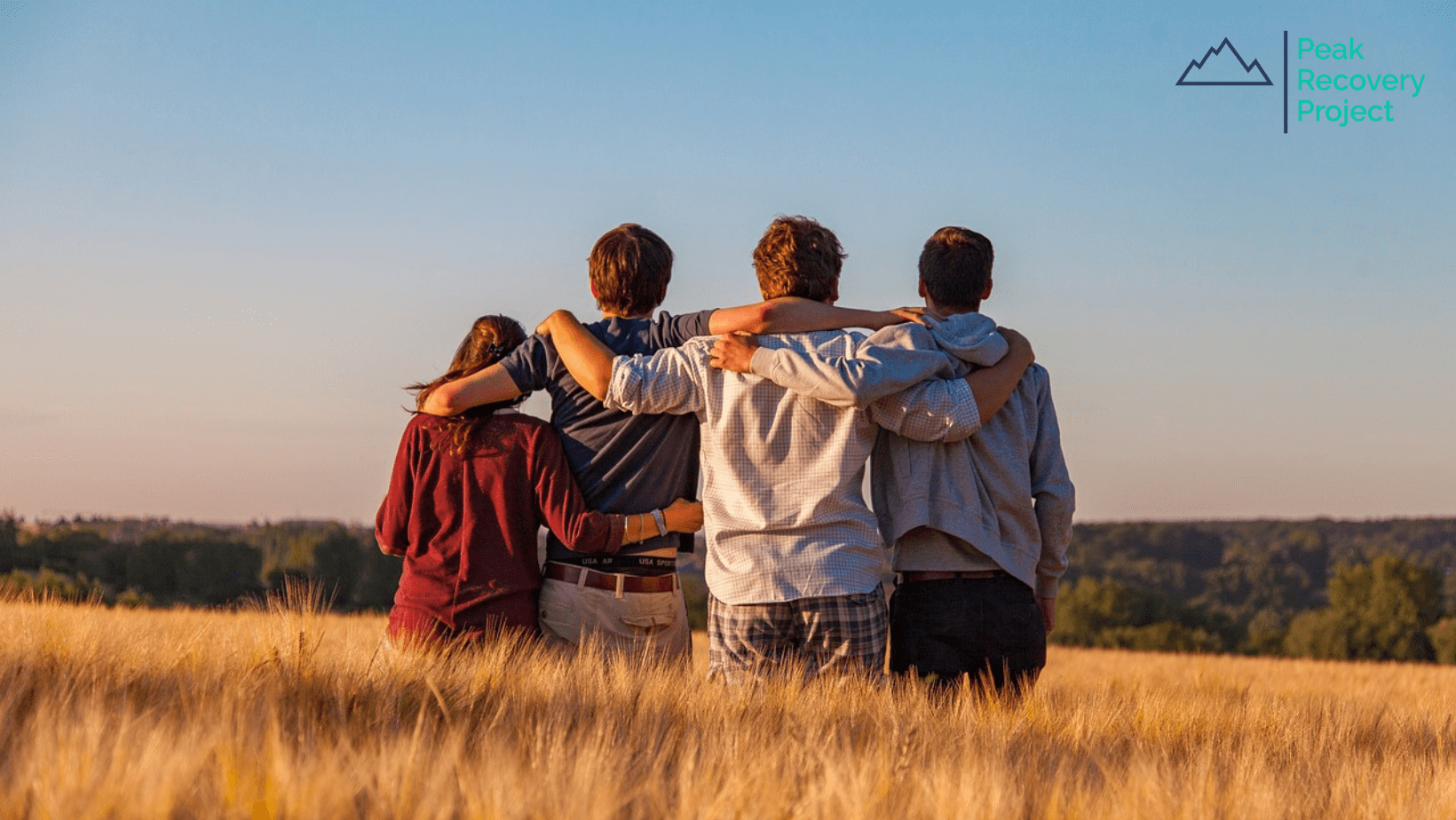 friends hugging in a field 